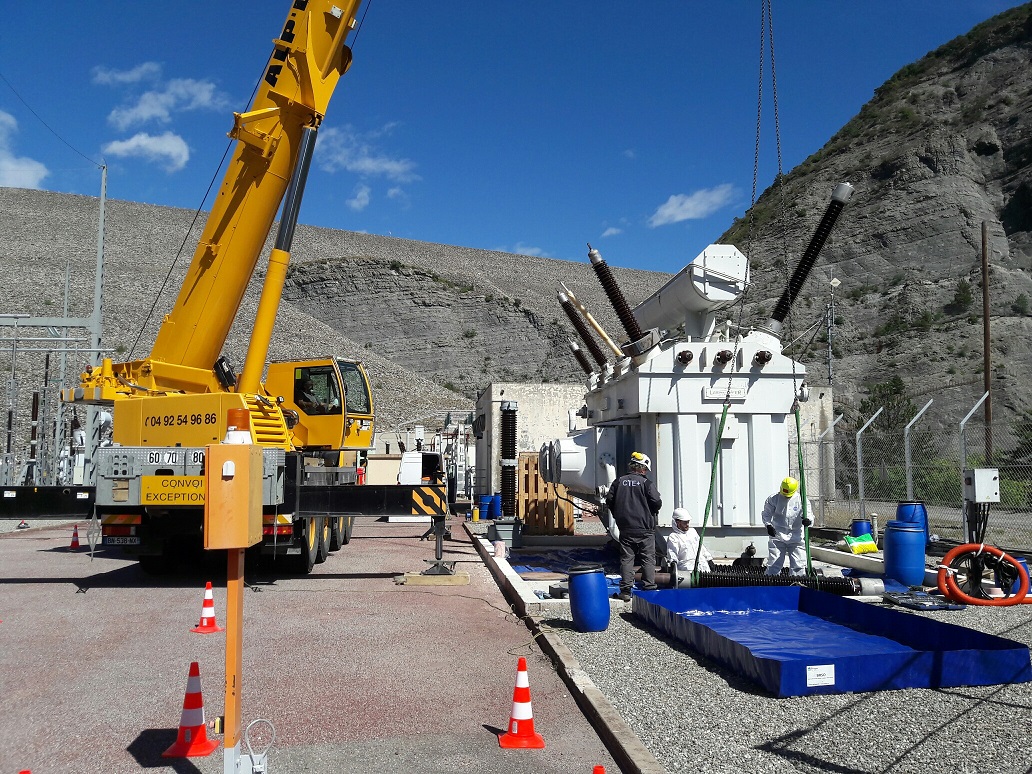 Préparation au levage de la cloche pour démontage d'un Transformateur RTE au barrage de Serre-Ponçon. Les équipes CTE+ déposent les traversées.
