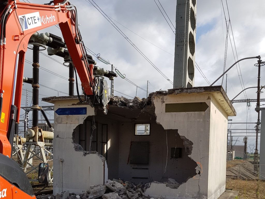 Démolition d'un bâtiment de relayage (BR) avec pince cisaille.